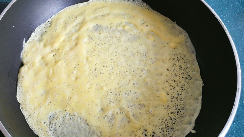 不一样的春卷（博山春卷）,锅里倒入打好的蛋液，快速转动锅，让蛋液铺满锅底，等蛋液凝固后翻面，一个蛋皮就做好了。
