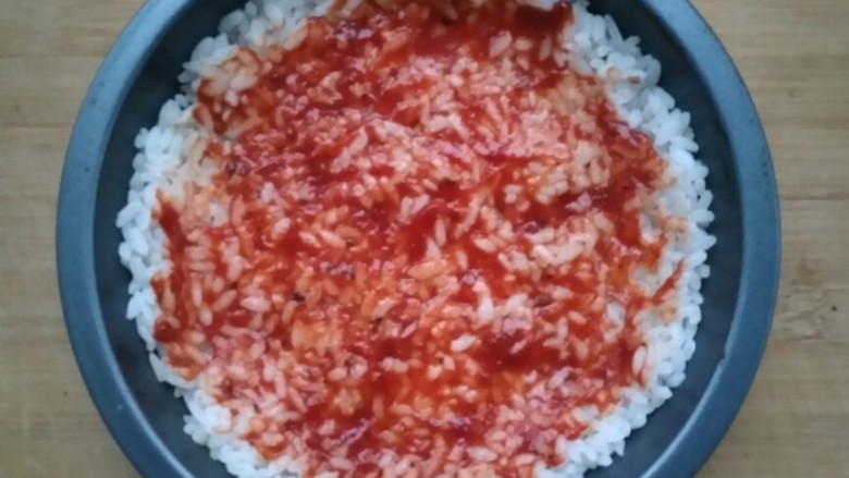 剩米饭别再炒着吃，这样做好吃到哭！😊,将披萨酱均匀的抹在米饭上。