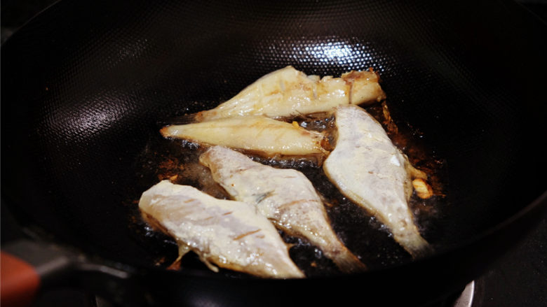 干烧耗儿鱼,下油锅炸的时候，稍等片刻，让一面尽量成金黄色后，再去翻动，不然肉就散掉了。

有两条没有抹粉的耗儿鱼，肉已经渐渐地黏在锅上，直至最后出炉的时候，只剩骨架横立。
