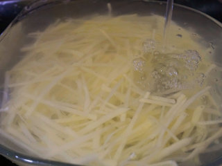 捞汁土豆丝,将土豆去皮切片后改刀成丝，放在流水下冲去多余的淀粉

叨叨叨：土豆切好后一定要多清洗几遍，然后用水冲洗掉多余的淀粉
