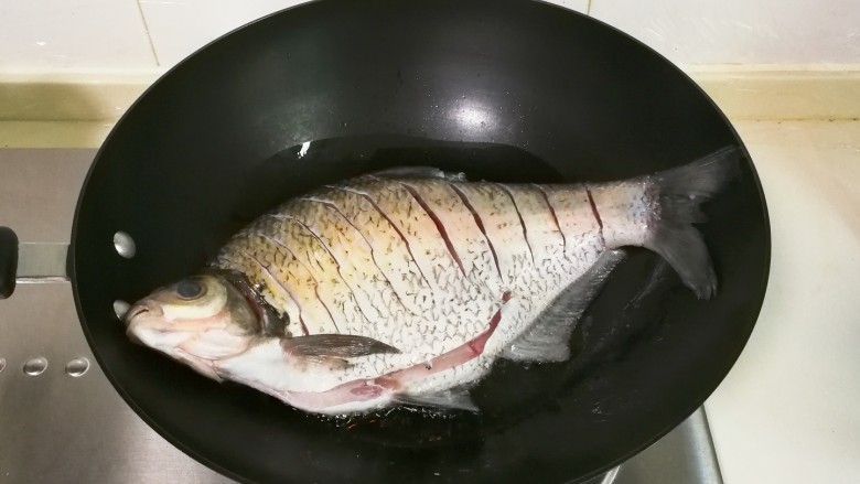 红烧蒜苔鳊鱼,调小火放入提前擦干水分的鳊鱼