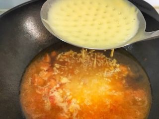 辅食10M➕：番茄鸡蛋疙瘩面,将面糊放在漏勺上，用刮刀压一下，面糊会穿过漏勺，遇到开水后就能成型