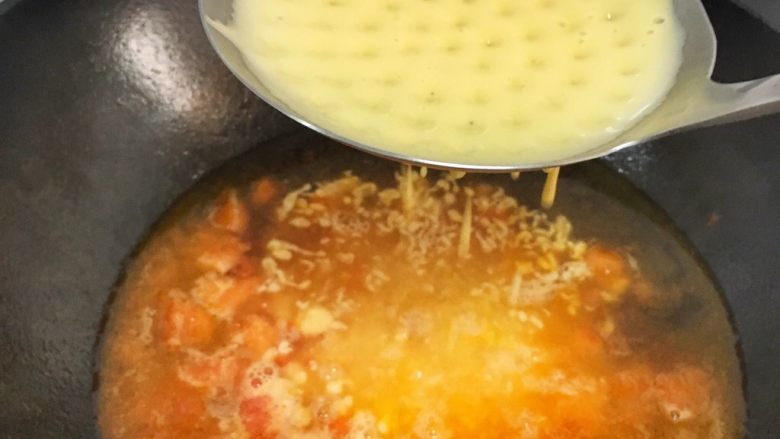 辅食10M➕：番茄鸡蛋疙瘩面,将面糊放在漏勺上，用刮刀压一下，面糊会穿过漏勺，遇到开水后就能成型