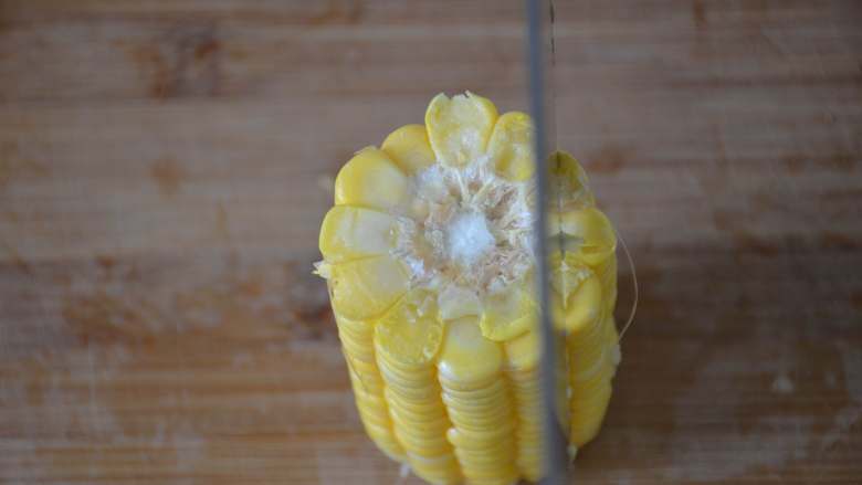 黄金玉米烙,把玉米立起来，用刀贴着玉米棒垂直切下玉米粒。