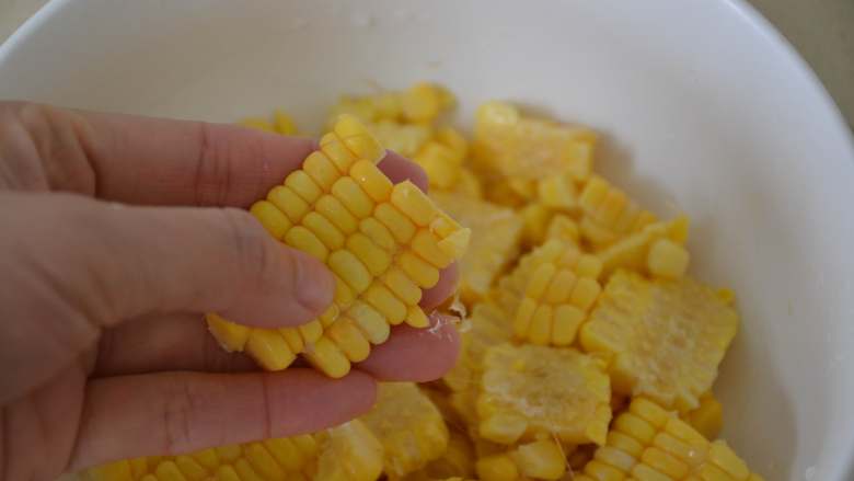黄金玉米烙,用手将粘在一起的玉米搓开。