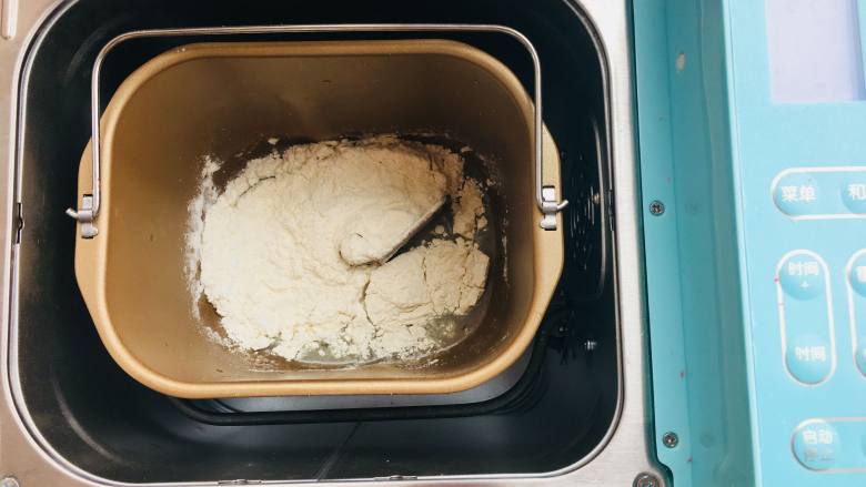 传统蛋黄酥,将混合好的粉类倒入面包机中。启动和面功能。