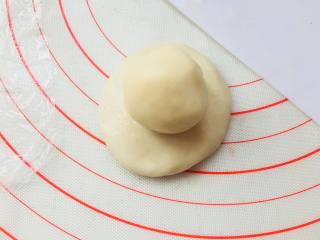 传统蛋黄酥,松弛过后，取一个油皮按成圆形，放置油酥球在上面