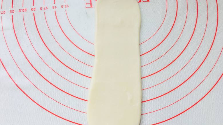 传统蛋黄酥,取一个面团卷，有螺旋开口的位置朝上下，侧面收口放于底部，按扁擀长。同样力度不可太大