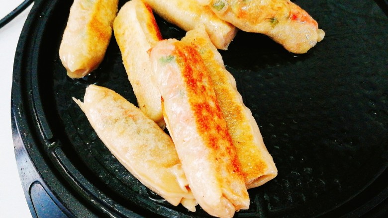 辅食计划+萝卜丝卷,做好的萝卜丝饼皮薄馅鲜，隔着皮隐约能看到馅中的红色火腿丁。