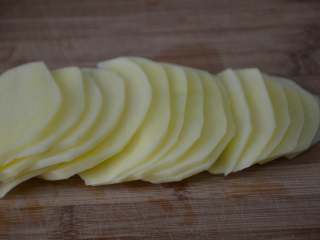 凉拌土豆丝,将土豆切成薄片，尽量均匀，土豆片按照原来的顺序排列，在菜板上码放整齐。