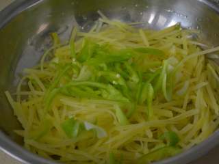 凉拌土豆丝,将葱花和青椒丝放入土豆丝内。
