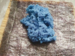 #辅食计划#“蓝钻”水果寿司,一张海苔铺在寿司帘上，码一勺米饭放在上面