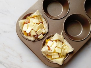 鸡蛋吐司杯盏,铺上切小块的奶酪片