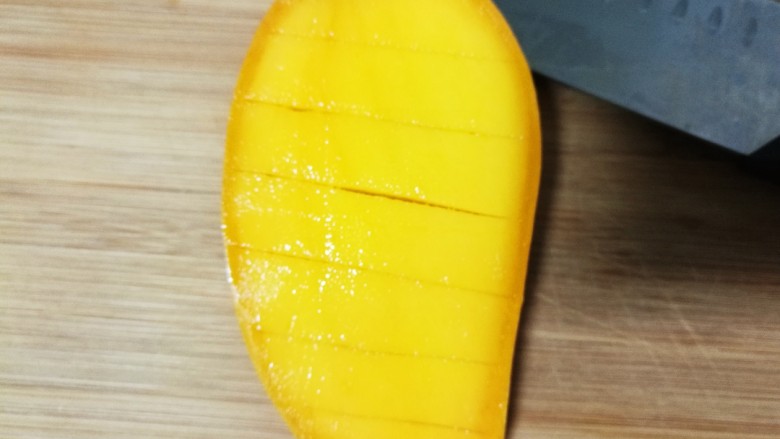 酸奶水果捞,芒果先用刀横切。