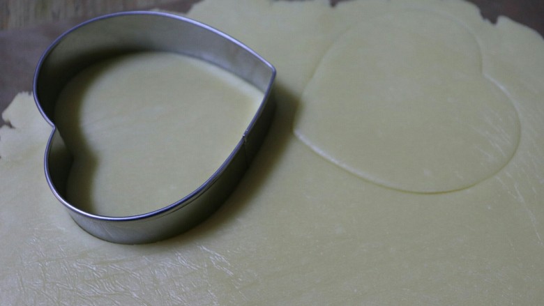 糖霜饼干之婚礼系列,用心形的饼干模具压出形状，把饼干转移到铺了油纸的烤盘上。