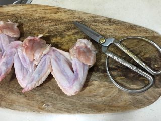 鸡翅包饭,准备一把锋利的剪刀,把鸡翅的骨头小心翼翼的剪出来,要避免把皮戳破了。最后一节的鸡尖是不用脱骨的.(这有点考验耐心)