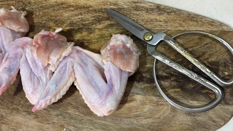 鸡翅包饭,准备一把锋利的剪刀,把鸡翅的骨头小心翼翼的剪出来,要避免把皮戳破了。最后一节的鸡尖是不用脱骨的.(这有点考验耐心)