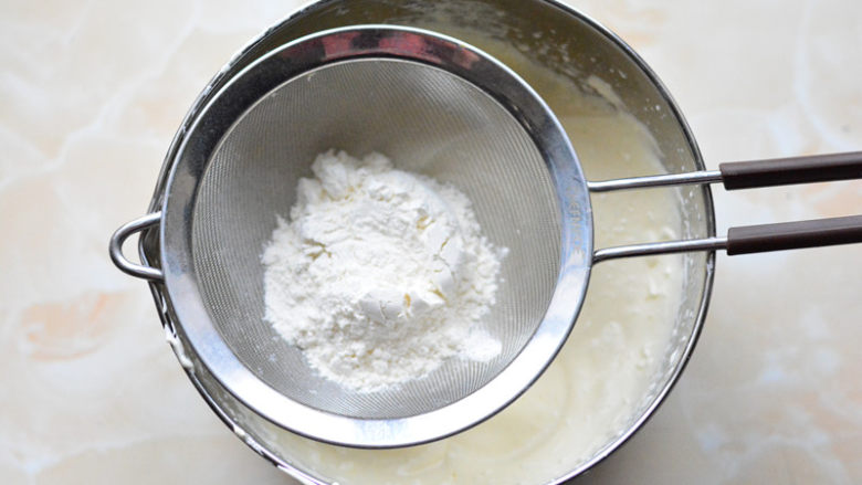 抹茶杯子蛋糕,筛入低筋面粉，（过筛的主要作用是可以去除粉类储存过程中产生的结块，让面粉更蓬松），用手动打蛋器搅拌至面粉无颗粒状

