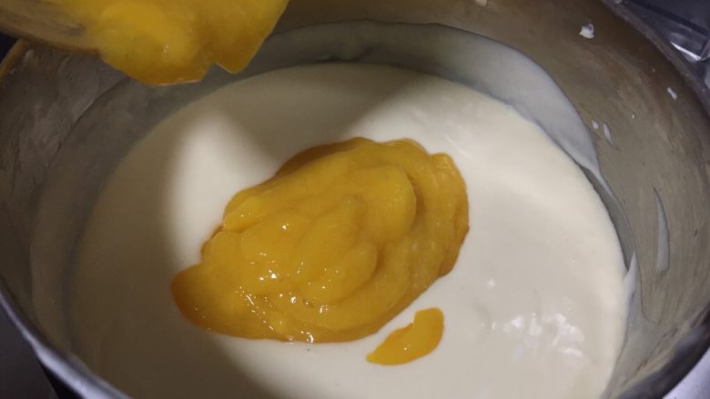 芒果慕斯蛋糕,倒入芒果泥搅拌均匀，留少许果泥来做镜面
