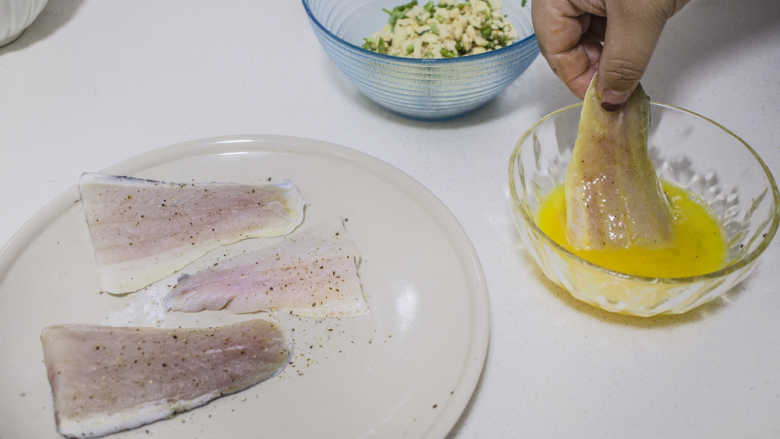 脆皮花生巴沙鱼块配酸辣酱,将鱼块裹上蛋液