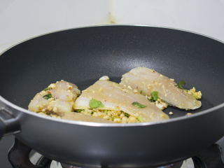 脆皮花生巴沙鱼块配酸辣酱,锅中放油将沾有花生碎的的一面贴在锅里煎2分钟