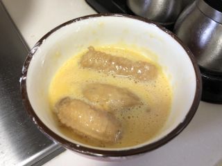 茶香鸡翅,腌制好的鸡翅放入蛋液中，蘸均匀后放入锅中煎炸。