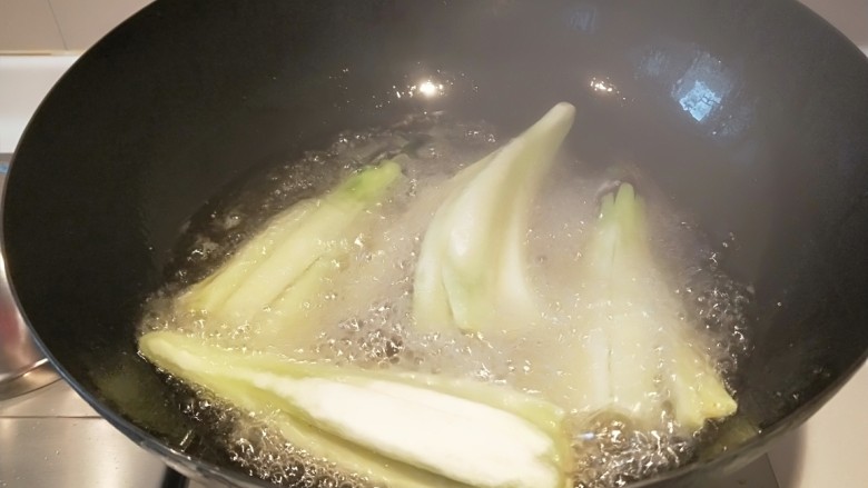 浇汁长条茄子,锅中放适量油烧七成热放入茄子。