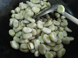 蚕豆炒野香葱,倒入蚕豆。