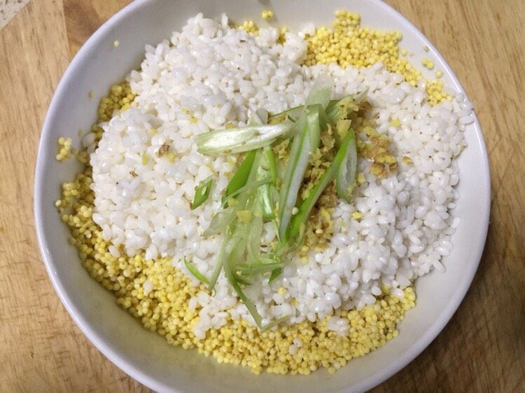糯小米蒸排骨,将小米和糯米倒入一个碗里加入之前剩余的大葱和老姜
