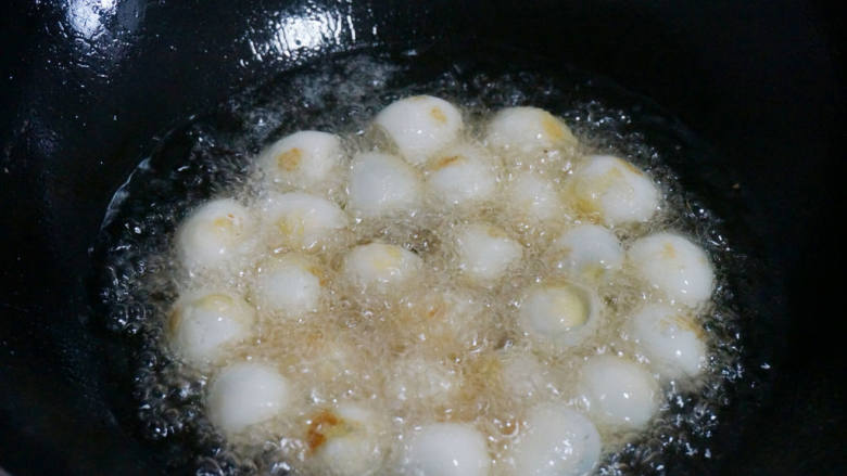 糖醋虎皮鹌鹑蛋,锅中放入适量的油，烧至六成热时，放入鹌鹑蛋中小火慢炸。