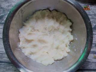 芝士拉丝热狗棒, 把蒸好的土豆压成泥，把淀粉放到土豆泥中，再放入少许黑胡椒粒，半勺盐。 搅拌均匀，如图。（如果土豆泥比较干的话，可以少放一点牛奶。）