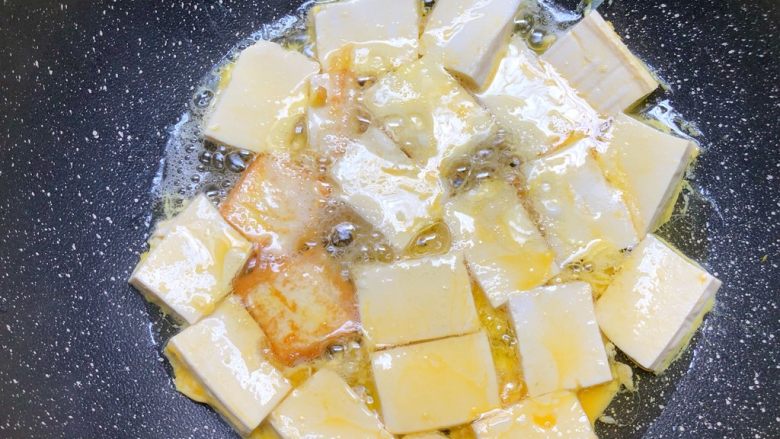 家常豆腐,热锅热油，放入沾满蛋液的豆腐，中火煎制金黄