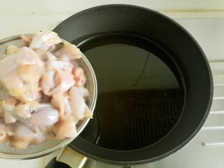 干锅牛蛙,锅里放油烧热，油量略大，用漏网把碗里的牛蛙捞到锅里，滑油。