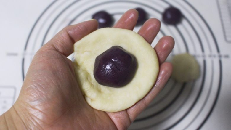 旋风紫薯油酥烧饼,取油皮一个按扁，包入一个油酥，然后捏紧边缘，最后滚圆
