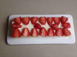 草莓层叠蛋糕,一片蛋糕抹上打发好的奶油铺上切成片的草莓。