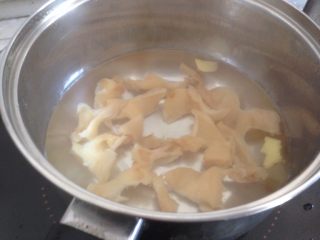 花胶焖鸡,花胶切小块，加入姜片，放入水中煮10分钟。