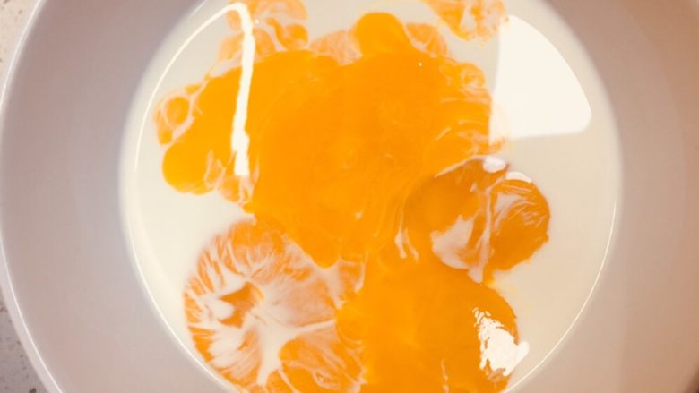 黄桃蛋挞,加蛋黄，继续和匀。如果之前加热的，凉冷再加蛋黄打。