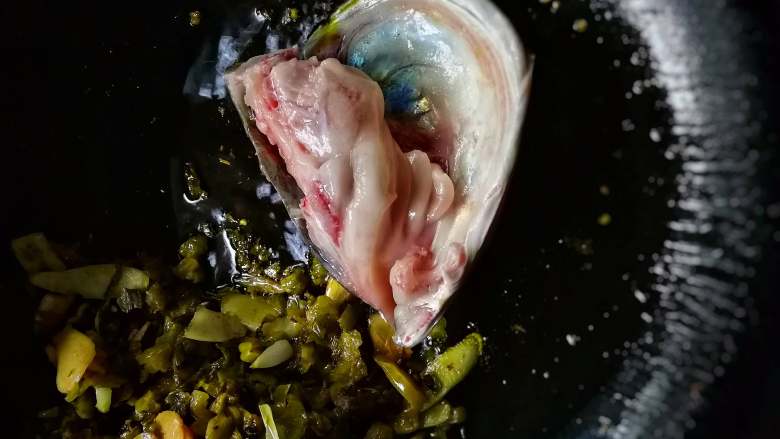 香锅酸菜鱼,炒好的酸菜料搁置一边，下鱼头