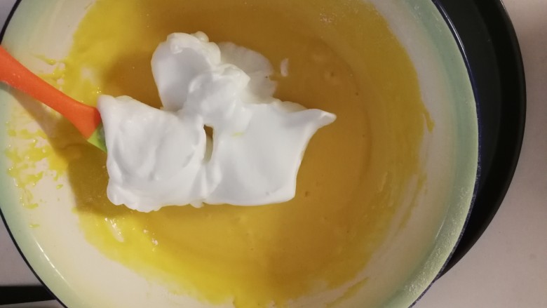 鸡蛋小松饼,打好的蛋白霜取1/3加入到蛋黄浆里 上下搅拌均匀后 再将所有蛋黄浆全部倒入蛋白霜里面充分搅拌均匀 