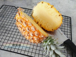 菠萝咕咾肉,备好一颗熟透的菠萝切开，如图中带叶的那一块，要稍大一点