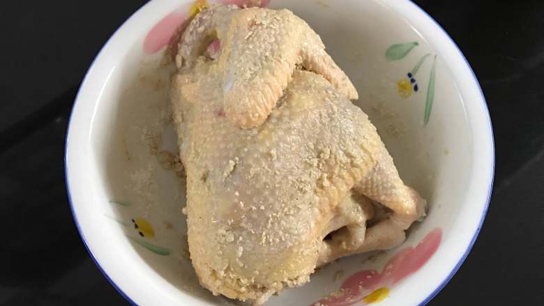 砂锅烤窑鸡,然后把混合好的沙姜盐均匀地抹在鸡身上，里面也上抹上。