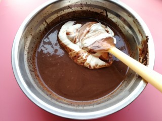 六寸巧克力淋面慕斯蛋糕,将打发好的淡奶油倒入巧克力糊里面搅拌。