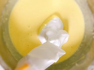 轻乳酪蛋糕（芝士蛋糕）,取1/3蛋白霜加入面粉糊内，用橡皮刮刀翻拌均匀。然后倒回剩下的2/3蛋白霜内混拌均匀。