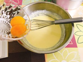 轻乳酪蛋糕（芝士蛋糕）,分次加入蛋黄，用手动打蛋器搅拌均匀。
