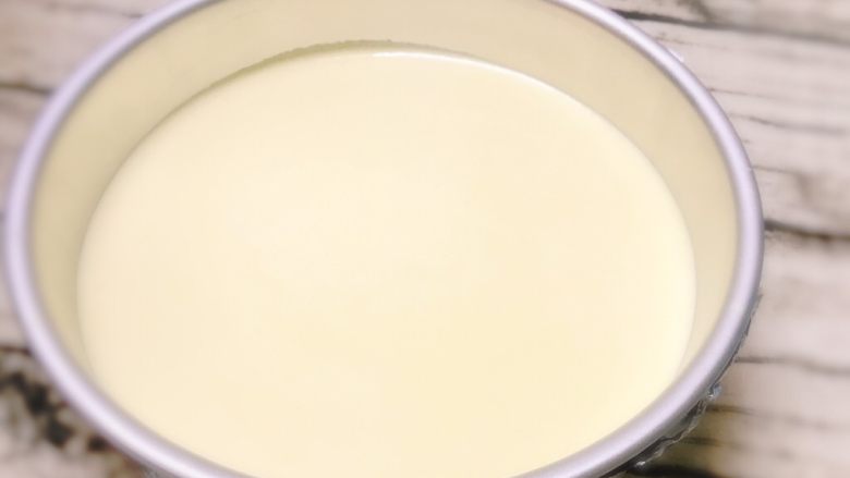 轻乳酪蛋糕（芝士蛋糕）,倒入底部包有锡纸的活底圆形蛋糕模具内。放入先开始预热好的烤箱的倒数第二层，底部插一盘盛满水的烤盘，以15度烤40分钟后，再以170度烤20分钟即可。