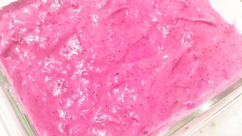 粉红火龙果牛奶小方,倒入到玻璃碗中用刮刀抹平，放入到冰箱冷藏两个小时