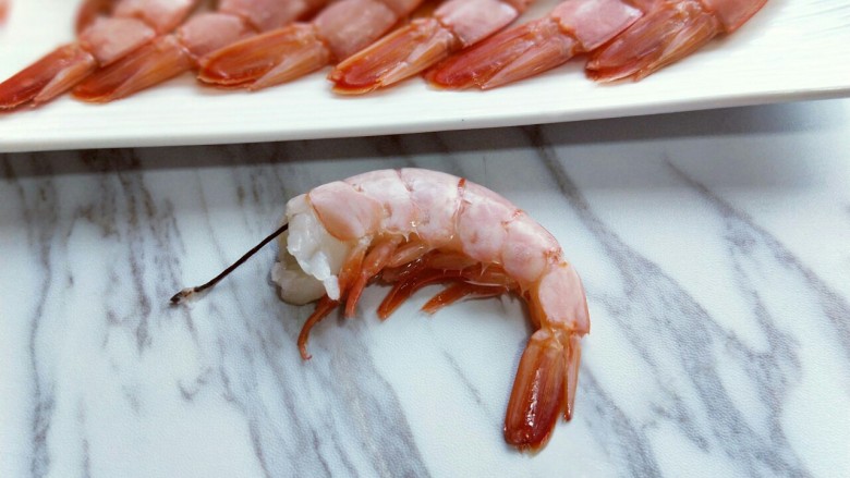 #辅食计划#黄金凤尾虾#煮蛋器版#,首先将红虾尾虾线，阿根廷红虾的虾线比较粗特别好去除，轻轻一拉就出来了。