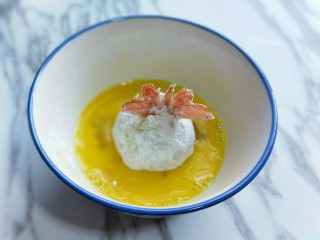 #辅食计划#黄金凤尾虾#煮蛋器版#,再放入打散的蛋液器具中，均匀裹上蛋液。