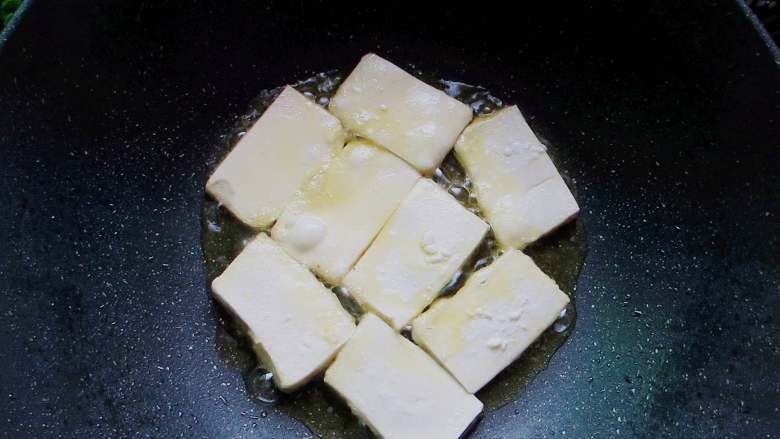 茄汁脆皮豆腐,锅里倒入菜籽油中小火慢煎，豆腐上撒一点细盐
