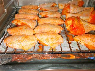 新奥尔良烤鸡翅鸡腿,烤盘铺上锡纸，放到烤架下面，把腌制好的鸡腿和鸡翅放到烤架上，烤箱预热，上下火220度烤15分钟